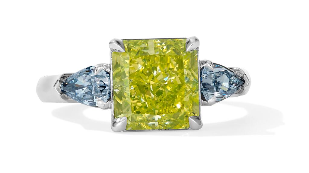 The “Kryptonite” ring features a 3.16-carat fancy vivid green-yellow radiant-cut diamond of SI1 clarity, accented by a pair of fancy intense blue pear-shaped diamonds weighing a total of 0.63-carats. Scott West Bruce Wayne Kryptonite Ring